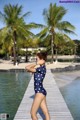 A woman in a polka dot swimsuit standing on a dock.