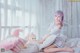 A woman sitting on a bed with stuffed animals.