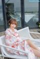 a woman sitting on a white chair in front of a window