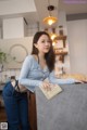 A woman leaning on a counter in a kitchen.