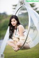 A woman sitting on a swing in a park.