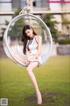 A woman sitting in a bubble chair in a park.