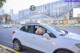 A woman is sitting in the driver's seat of a white car.