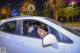 A woman sitting in the driver's seat of a white car.