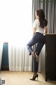 A woman leaning against a dresser in a hotel room.