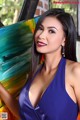 A woman in a blue dress posing in front of a painting.
