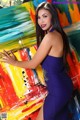 A woman in a blue dress posing in front of a painting.