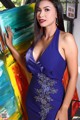 A woman in a blue dress posing in front of a painting.