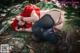 A woman in a red dress is laying on a rock.