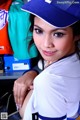 A woman in a baseball uniform posing for a picture.