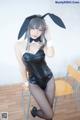 A woman in a black bunny costume posing for a picture.