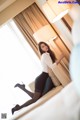 A woman sitting on a couch in a hotel room.