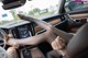 A woman sitting in the driver's seat of a car with her legs up.