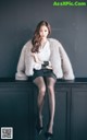 A woman sitting on top of a black cabinet.