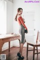 A woman standing in front of a wooden table.