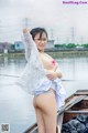 A woman in a white lingerie posing on a boat.