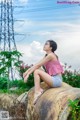 A woman sitting on top of a wooden log.