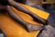 A pair of black stockings sitting on top of a wooden table.