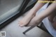 A woman sitting on a chair with her feet up.