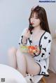 A woman sitting on a chair eating a bowl of fruit.