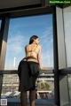 A woman standing on a balcony looking out a window.