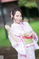 A woman in a pink and green kimono posing for a picture.