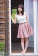 A woman standing in front of a sliding glass door.