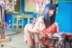 A woman in a red and white outfit sitting on a table.