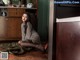 A woman sitting on the floor in a kitchen.