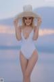 A woman in a white bathing suit and a straw hat.