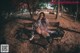 A woman sitting on a bench in a park at night.