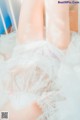 A close up of a woman's legs in a white dress.