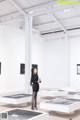 A woman standing in a room filled with white tables.