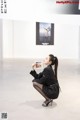 A woman sitting on the ground holding a book.