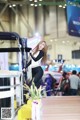 A woman standing on top of a table next to a car.