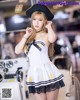 A woman in a sailor outfit posing in front of a boat.