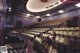 A woman sitting in the middle of an empty theater.