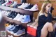 a woman sitting on top of a shelf next to a bunch of shoes