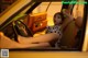 A woman sitting in the driver's seat of a yellow car.