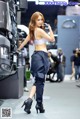 A woman standing in front of a truck talking on a cell phone.