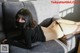 A woman laying on a couch wearing a black mask.