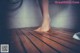 A woman standing on a wooden floor in a bathroom.