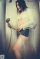 A woman in a raincoat is taking a shower.