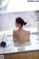 A woman sitting in a hot tub with her back to the camera.