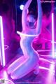 A naked woman in a neon room with a mask on.