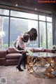 A woman in a maid outfit cleaning a coffee table.