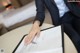 A woman in a business suit sitting at a table with a pen and paper.