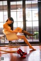 A woman sitting in a chair with her legs crossed.