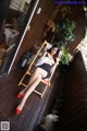 A woman sitting in a chair on a wooden deck.