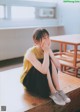 A woman sitting on a wooden bench covering her face with her hands.